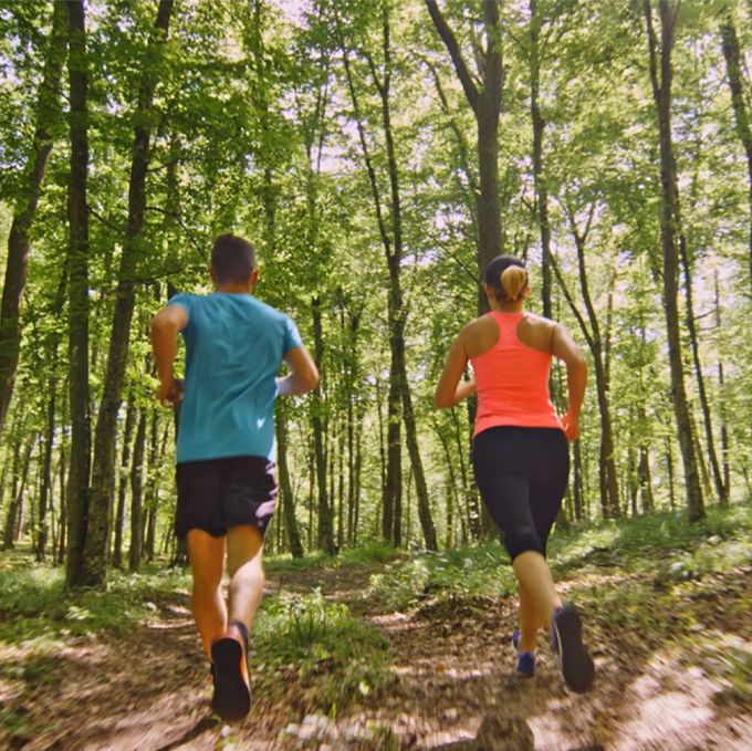 Couple running on a path in the woods